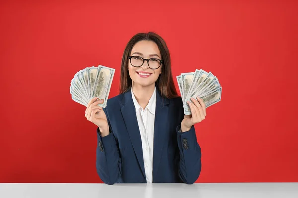 Junge Frau Mit Geld Tisch Vor Karminrotem Hintergrund — Stockfoto