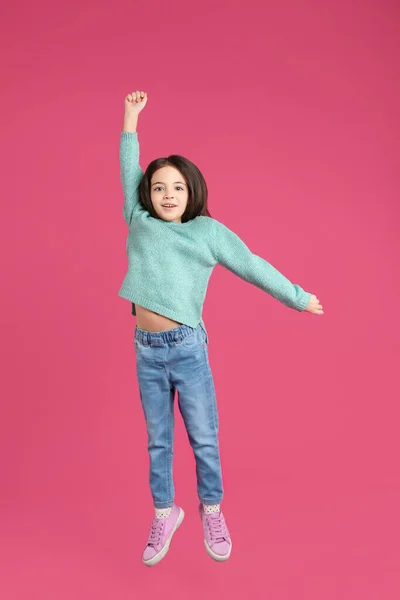 Pembe Arka Planda Zıplayan Tatlı Küçük Kız — Stok fotoğraf