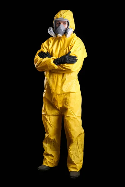 Man wearing chemical protective suit on black background. Virus research