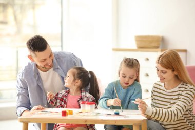 İçerideki masada güzel bir aile tablosu. Çocuklarla oynamak