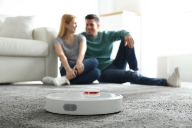 Robotik elektrik süpürgesi evde işini görürken çift birlikte vakit geçiriyor.