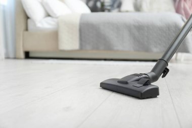Modern elektrik süpürgesiyle yerleri süpürüyor. Metin için boşluk