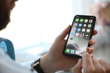 MYKOLAIV, UKRAINE - 16 Mart 2020: iPhone 11 'i elinde tutan adam kapalı alanda, yakın plan