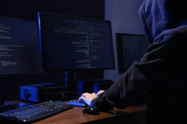 Karanlık odada bilgisayarları olan bir bilgisayar korsanı. Siber Suçlar