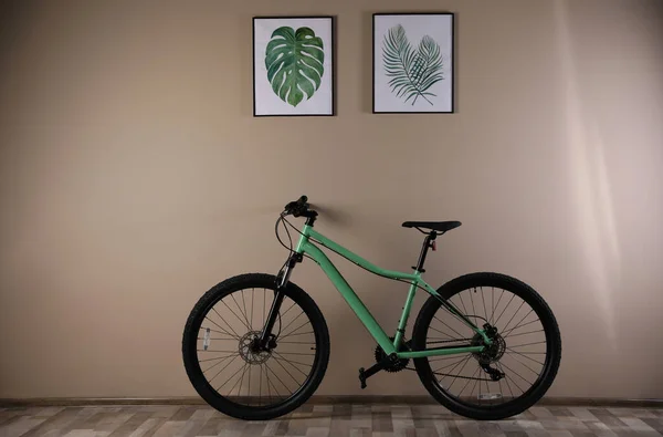 Современный Зеленый Велосипед Возле Бежевой Стены Помещении — стоковое фото