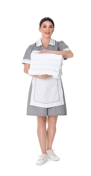 年轻的女服务员拿着一堆白色背景的新毛巾 — 图库照片