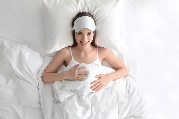 若いです女性とともに睡眠マスク寝そべって快適な枕の上に家で トップビュー — ストック写真