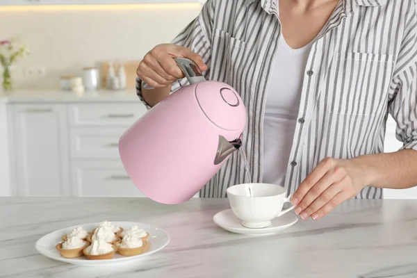 Vrouw Gieten Warm Water Uit Moderne Elektrische Waterkoker Kopje Binnen — Stockfoto