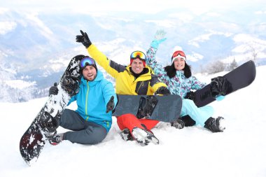 Dağdaki tatil köyünde snowboard yapan arkadaşlar. Kış tatili