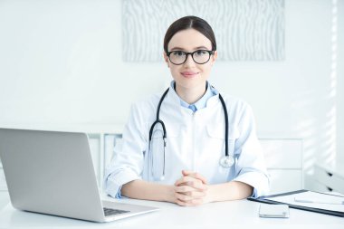 İş yerinde beyaz önlüklü genç kadın doktor portresi
