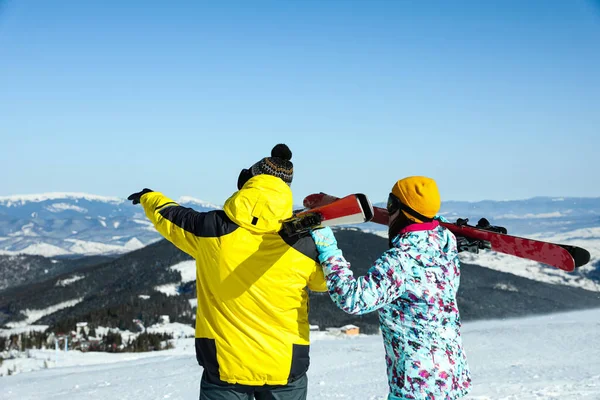 山の中でスキー用具を持つカップル バックビュー 冬休み — ストック写真