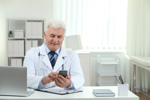 Médico Sênior Com Smartphone Mesa Escritório — Fotografia de Stock