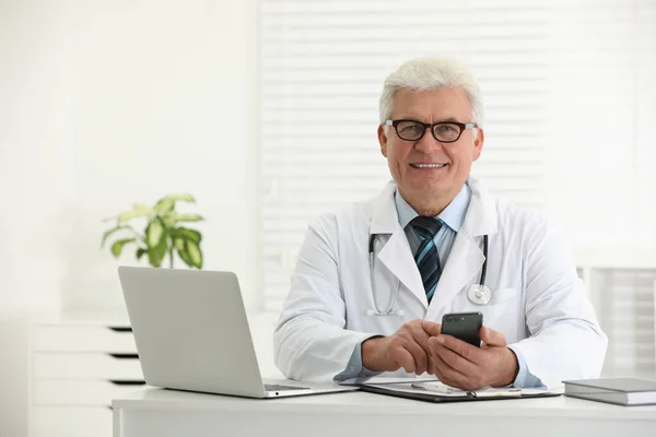 Médico Sênior Com Smartphone Mesa Escritório — Fotografia de Stock