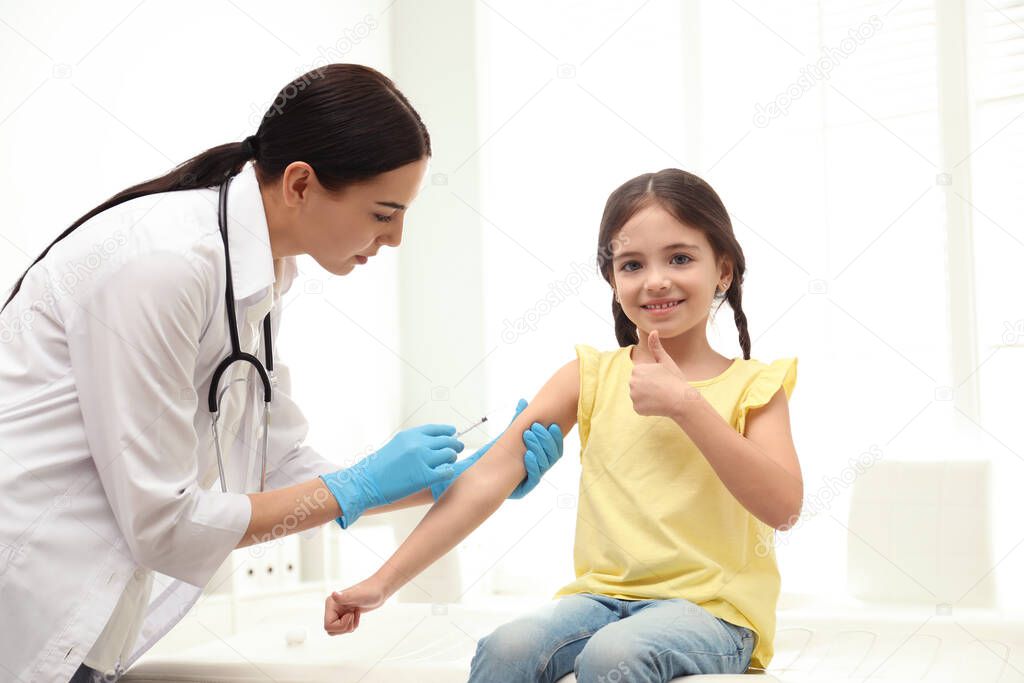 Doctor vaccinating little child in modern clinic