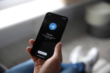 MYKOLAIV, UKRAINE - 16 Mart 2020: Kapalı alanlarda Telegram uygulamalı iPhone 11 'i tutan adam