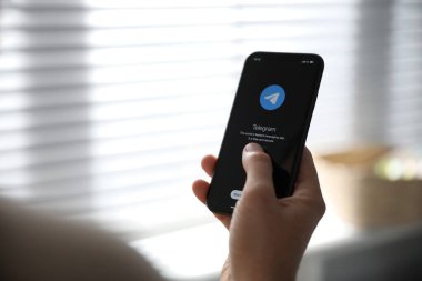 MYKOLAIV, UKRAINE - 16 Mart 2020: Kapalı alanlarda Telegram uygulamalı iPhone 11 'i tutan adam