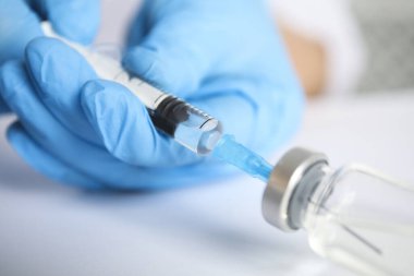Şırıngayı ilaçla dolduran doktor, yakın çekim. Aşılama ve aşılama