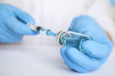Şırıngayı ilaçla dolduran doktor, yakın çekim. Aşılama ve aşılama