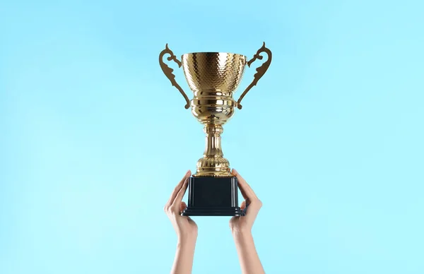 Mujer Sosteniendo Copa Trofeo Oro Sobre Fondo Azul Claro Primer —  Fotos de Stock