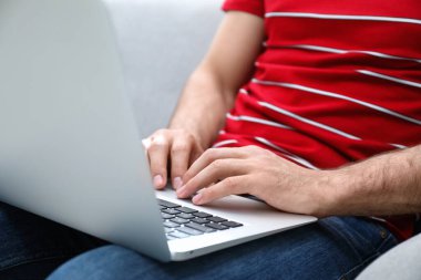 Evdeki modern dizüstü bilgisayarda çalışan adam, yakın plan