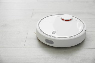 Yerleri süpürüp, modern robot süpürgeyle süpürüyor, kapalı alanda, yakın plan.
