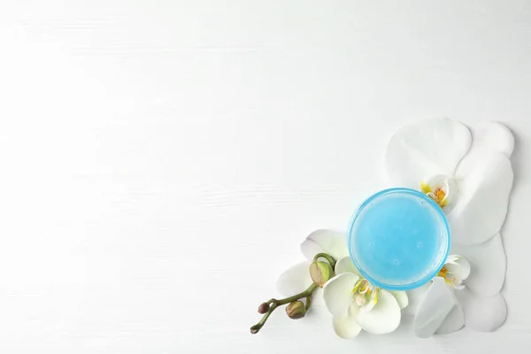 Beyaz Ahşap Masanın Üzerinde Kozmetik Jel Güzel Çiçeklerle Düz Bir — Stok fotoğraf