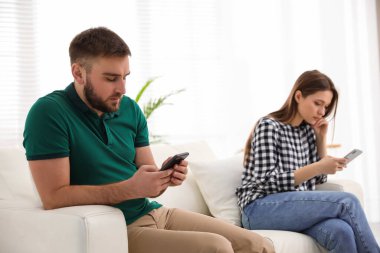 Evde birbirini görmezden gelen akıllı telefonlara bağımlı bir çift. İlişki sorunları