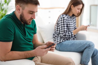 Evde birbirini görmezden gelen akıllı telefonlara bağımlı bir çift. İlişki sorunları