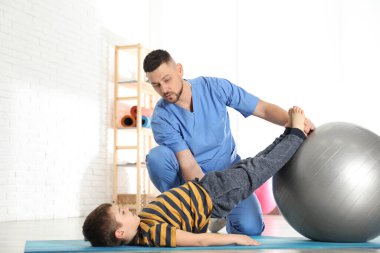 Hastanenin spor salonunda küçük bir çocukla çalışan ortopedist.