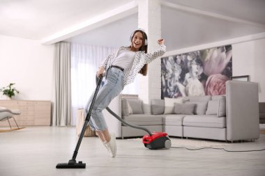 Evini süpürürken eğlenen genç kadın.