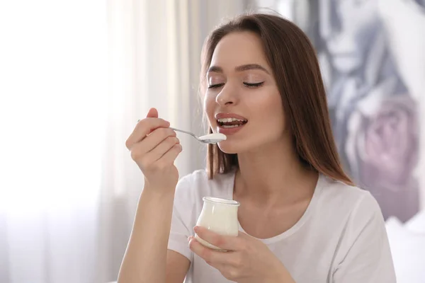 年轻迷人的女人在家里吃美味的酸奶 — 图库照片