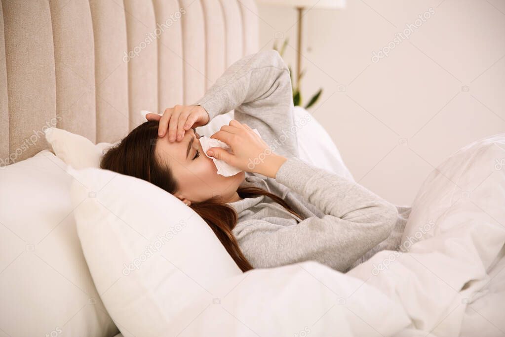Sick young woman in bed at home. Influenza virus