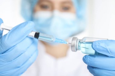 Şırıngayı ilaçla dolduran doktor, yakın çekim. Aşılama ve aşılama