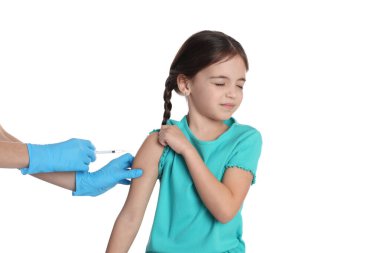 Beyaz arka planda küçük çocuğu aşılayan doktor.