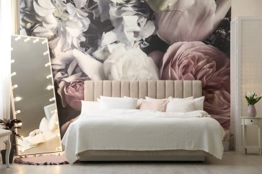 Büyük yataklı, aynalı ve çiçek desenli güzel bir oda.