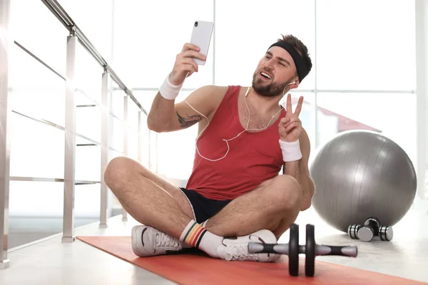 Jovem Preguiçoso Com Equipamento Desportivo Levando Selfie Dentro Casa — Fotografia de Stock