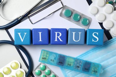 VIRUS sözcüğü olan küpler ve beyaz arka planda ilaçlar, düz konum