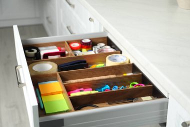 Açık masa çekmecesindeki farklı kırtasiye malzemeleri.