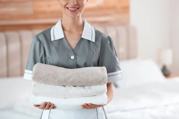 年轻的女服务员在卧室里抱着一堆新鲜的毛巾 特写镜头 — 图库照片