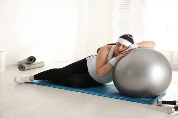 懒洋洋的胖女人靠健美球而不是在健身房训练 — 图库照片