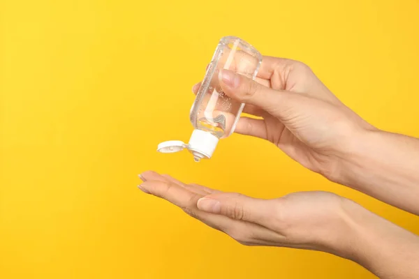 Mujer Aplicando Gel Antiséptico Sobre Fondo Amarillo Primer Plano —  Fotos de Stock