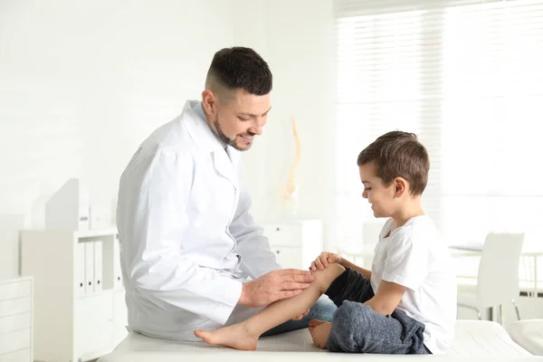 診療所で小さな患者の足を調べる専門整形外科医 — ストック写真