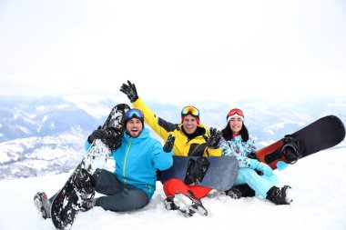 Dağdaki tatil köyünde snowboard yapan arkadaşlar. Kış tatili