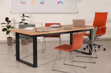 Konferans odasının içi modern ofis masasıyla dolu.