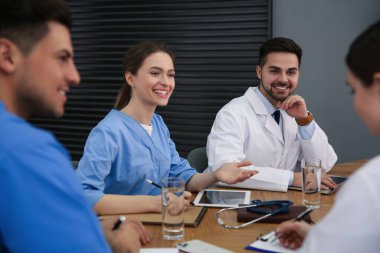 Profesyonel doktorlardan oluşan bir ekip ofisinde toplantı yapıyor.