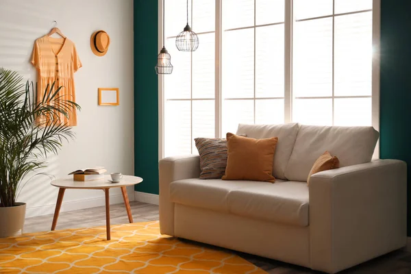 快適なソファとオレンジカーペットとスタイリッシュな部屋のインテリア — ストック写真