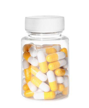 Beyaza izole edilmiş vitamin haplarıyla dolu şişe.