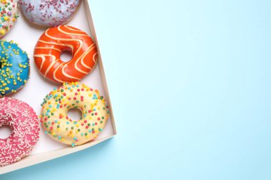 Açık mavi arka planda nefis jöleli donutlar, üst manzara. Metin için boşluk