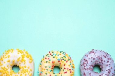 Turkuaz arka planda nefis jöleli donutlar, düz konum. Metin için boşluk