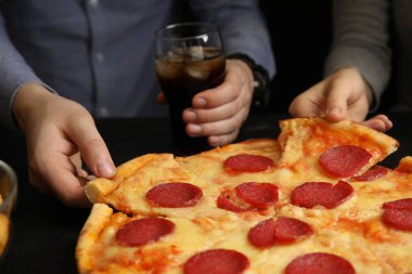 Arkadaşları masada lezzetli biberli pizza yiyor, yakın plan.